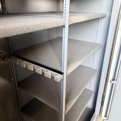 Side view of gun safe shelving interior with gray shelves.