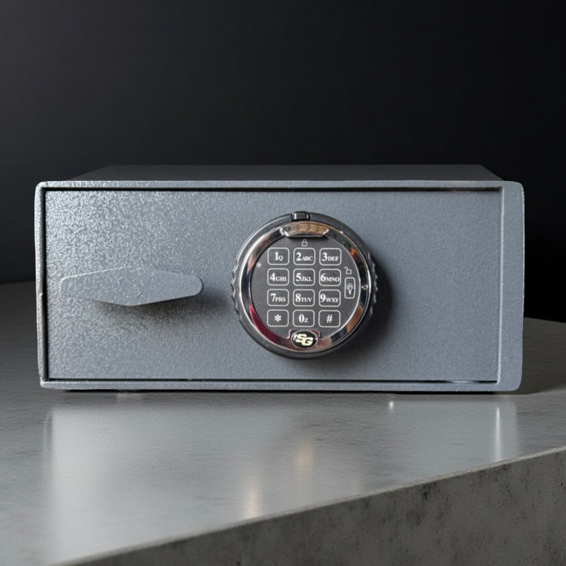 Small pistol safe box with digital keypad on a reflective surface