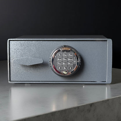 Small pistol safe box with digital keypad on a reflective surface