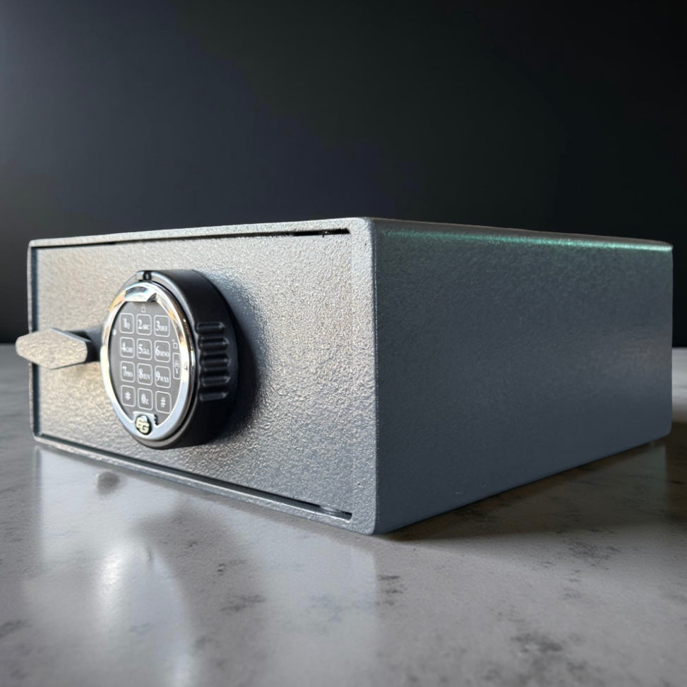 pistol safe box with digital keypad on a reflective surface