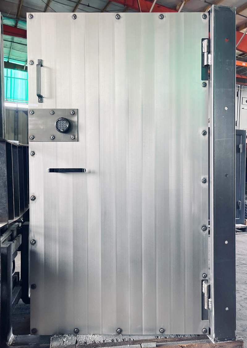Large stainless industrial vault door in a warehouse setting