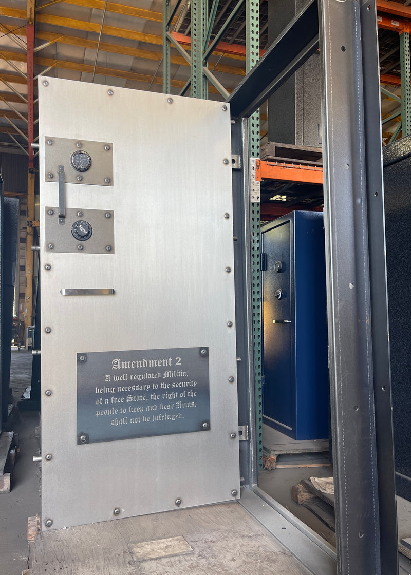 Metallic industrial vault door with a plaque on a warehouse background